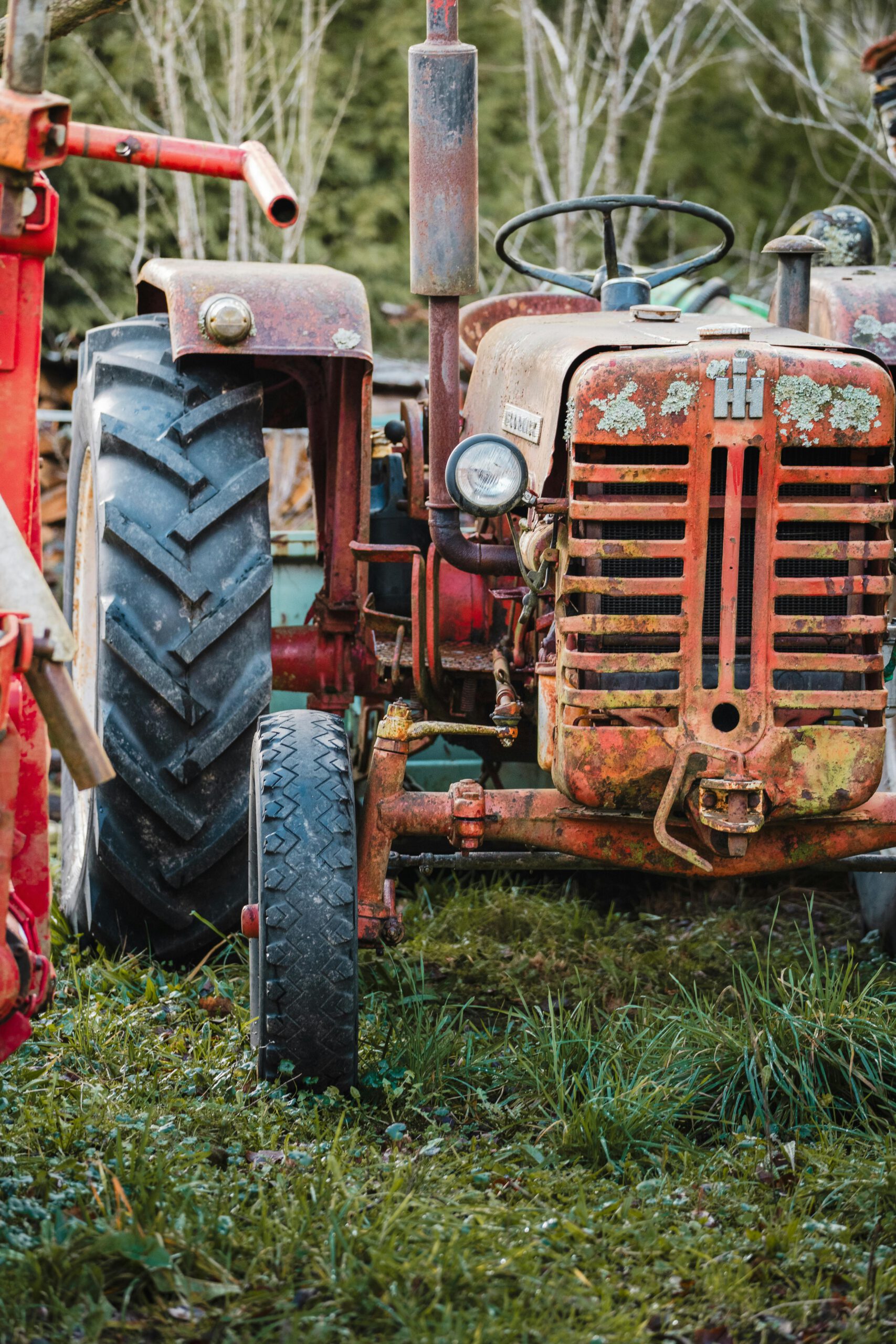 Close-up of an old rusty tractor on a rural farm, capturing decay and history.
